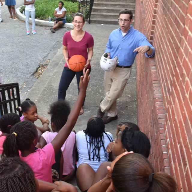 A photo shows nursing student Kathleen Littleton and pulmonary and critical care fellow Panagis Galiatsatos visiting Poe Homes.
