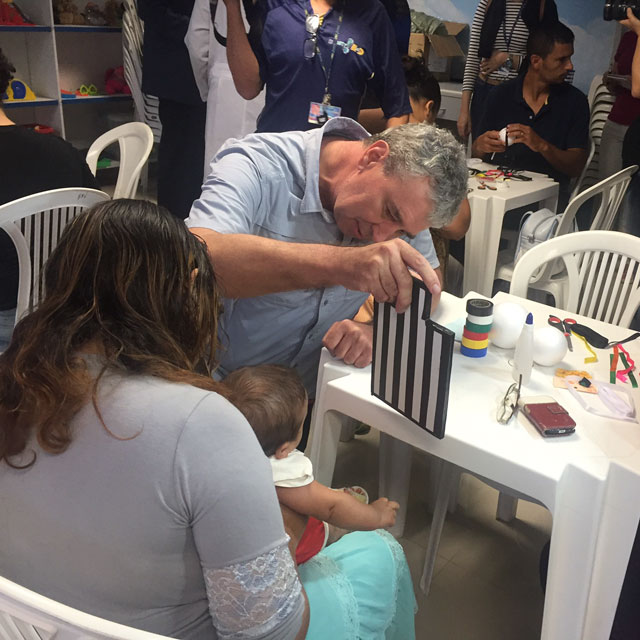 A photo shows William May with a baby affected by Zika. 
