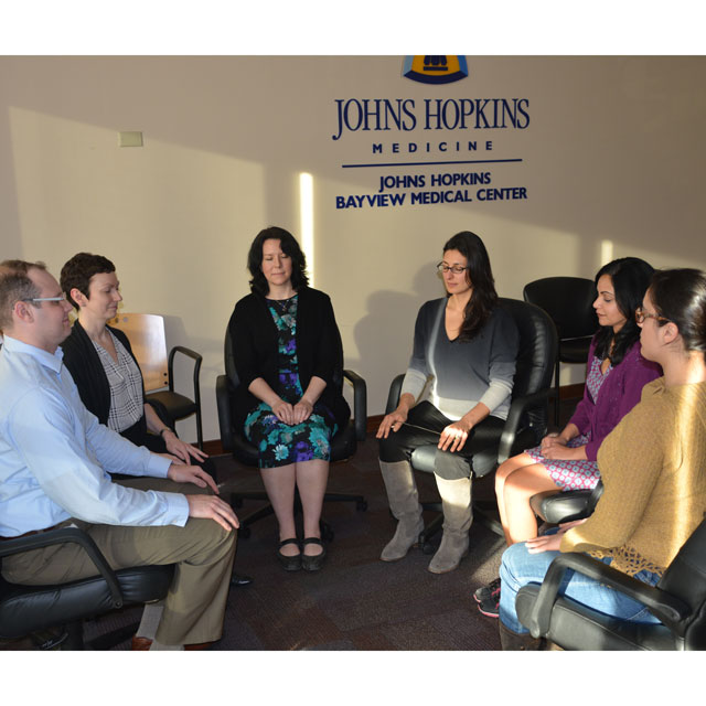 A photo shows Neda Gould leading a Mindfulness-Based Stress Reduction class for faculty members at the Johns Hopkins Bayview Medical Center.  