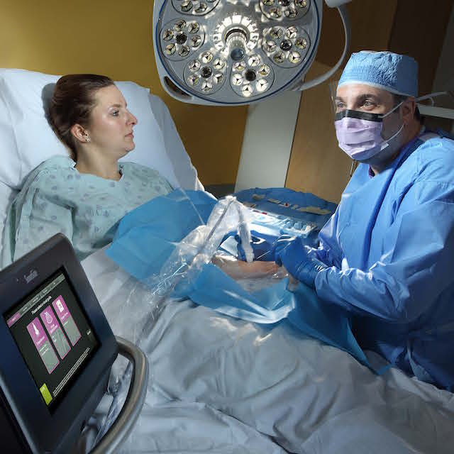 Photo of David Lictchman performing an image-guided procedure on a model. 