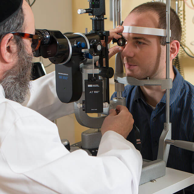 Photograph shows a routine eye exam by Eric Singman, division chief of the general eye service at the Wilmer Eye Institute.
