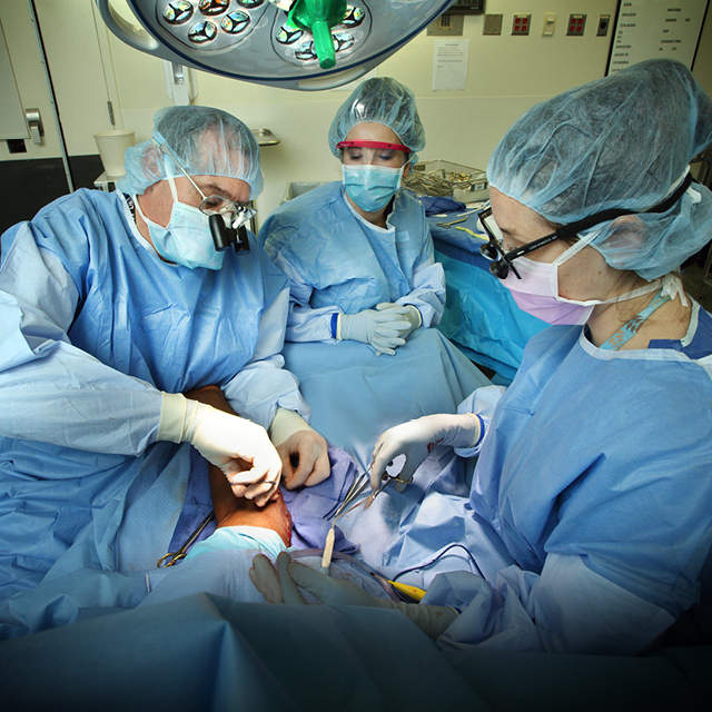 An image shows John Ingari operating with surgical technician Lauren Powell and orthopaedic surgery resident Lara Atwater.