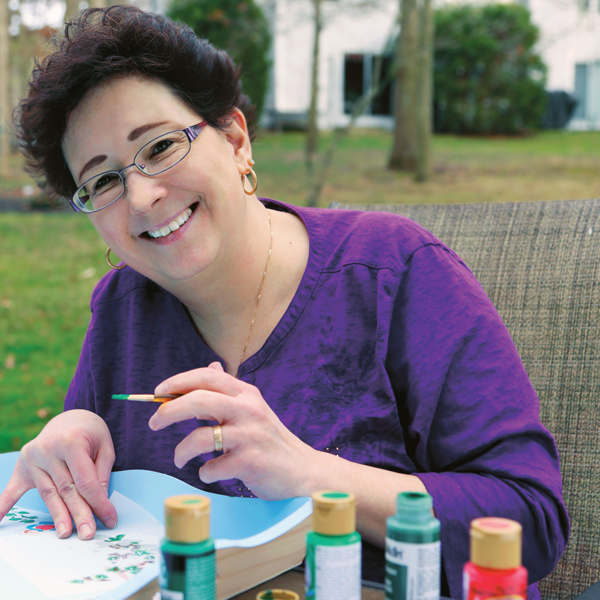 MaryJo Musselman stenciling and painting in her yard