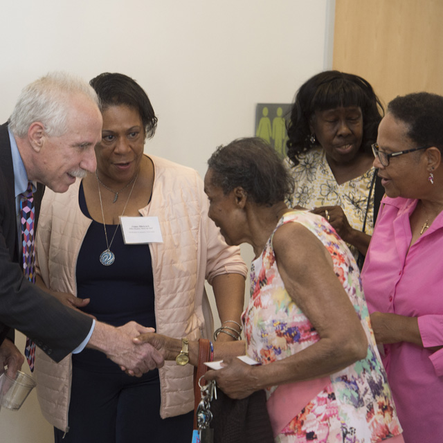 Paul Rothman, dean of the medical faculty and CEO of Johns Hopkins Medicine, greets Naomi Bennett, a member of the St. Wenceslaus Catholic Church. 