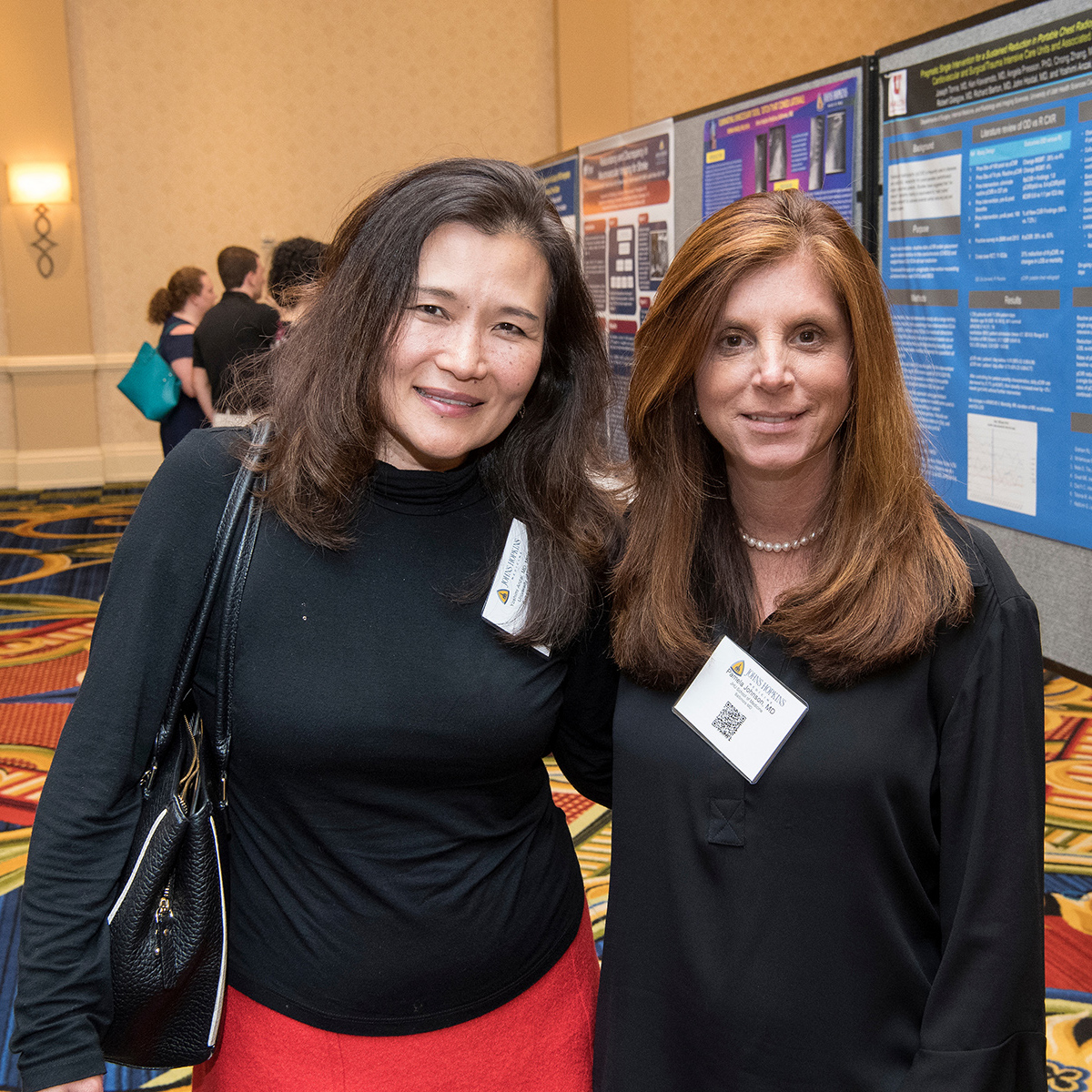Photos shows Yoshimi Anzai, associate chief medical quality officer at University of Utah Health Care, and conference organizer Pamela Johnson, vice chair of quality and safety in radiology at Johns Hopkins University School of Medicine, discussing improvements and innovations during the poster session.