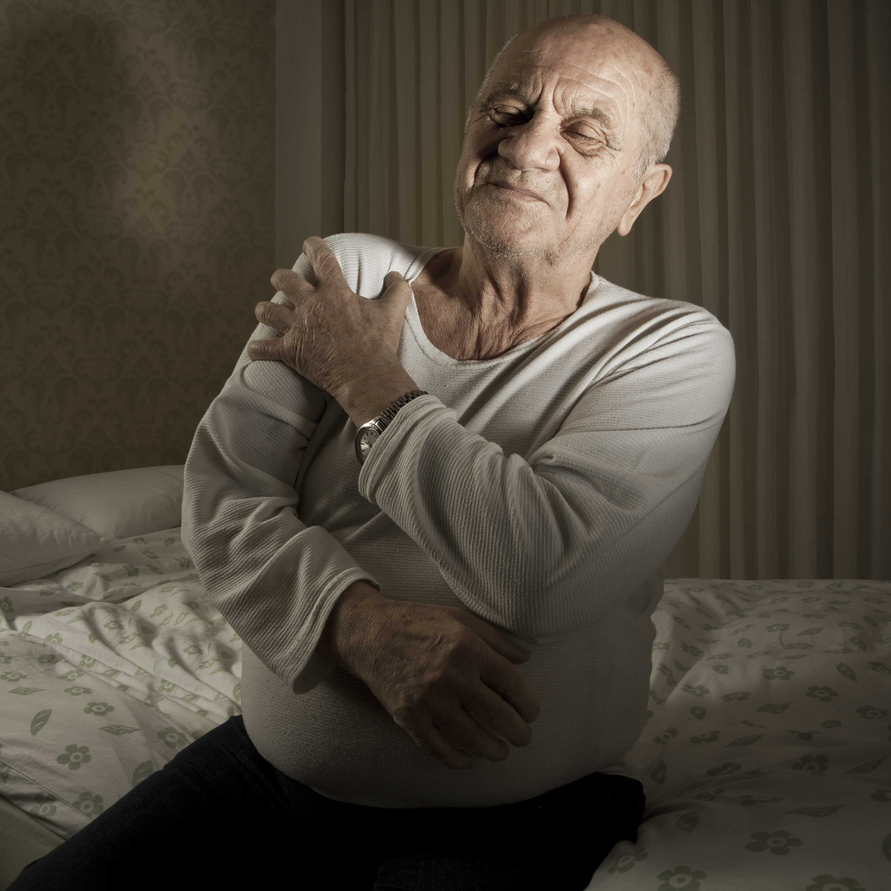 image of man in pain, holding arm