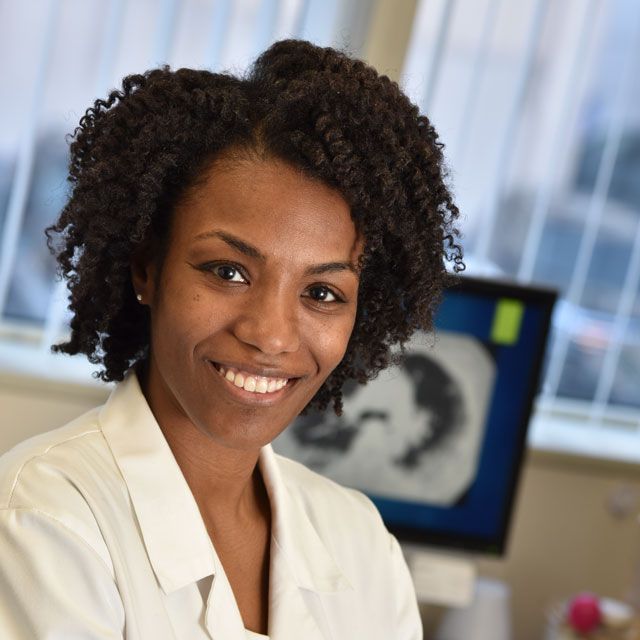 photo of Dr. Cheilonda Johnson, in a white coat, smiling. 