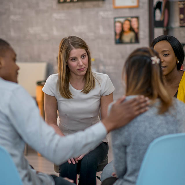 A photo shows a group of people having a discussion.