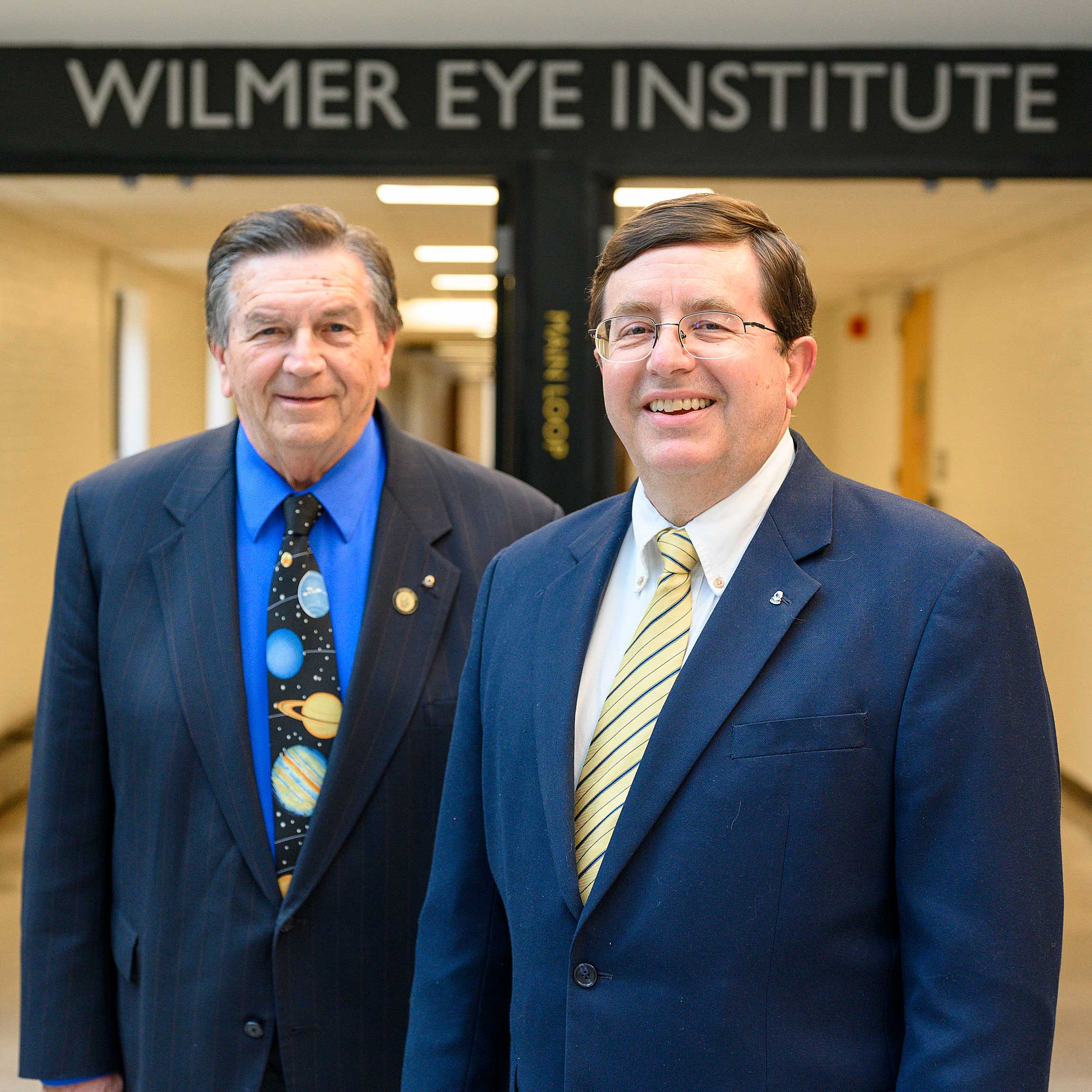 Lions John Shwed, left, and Larry Burton standing inside the Wilmer Eye Institute