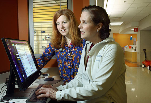 mixter and naughton look at a computer