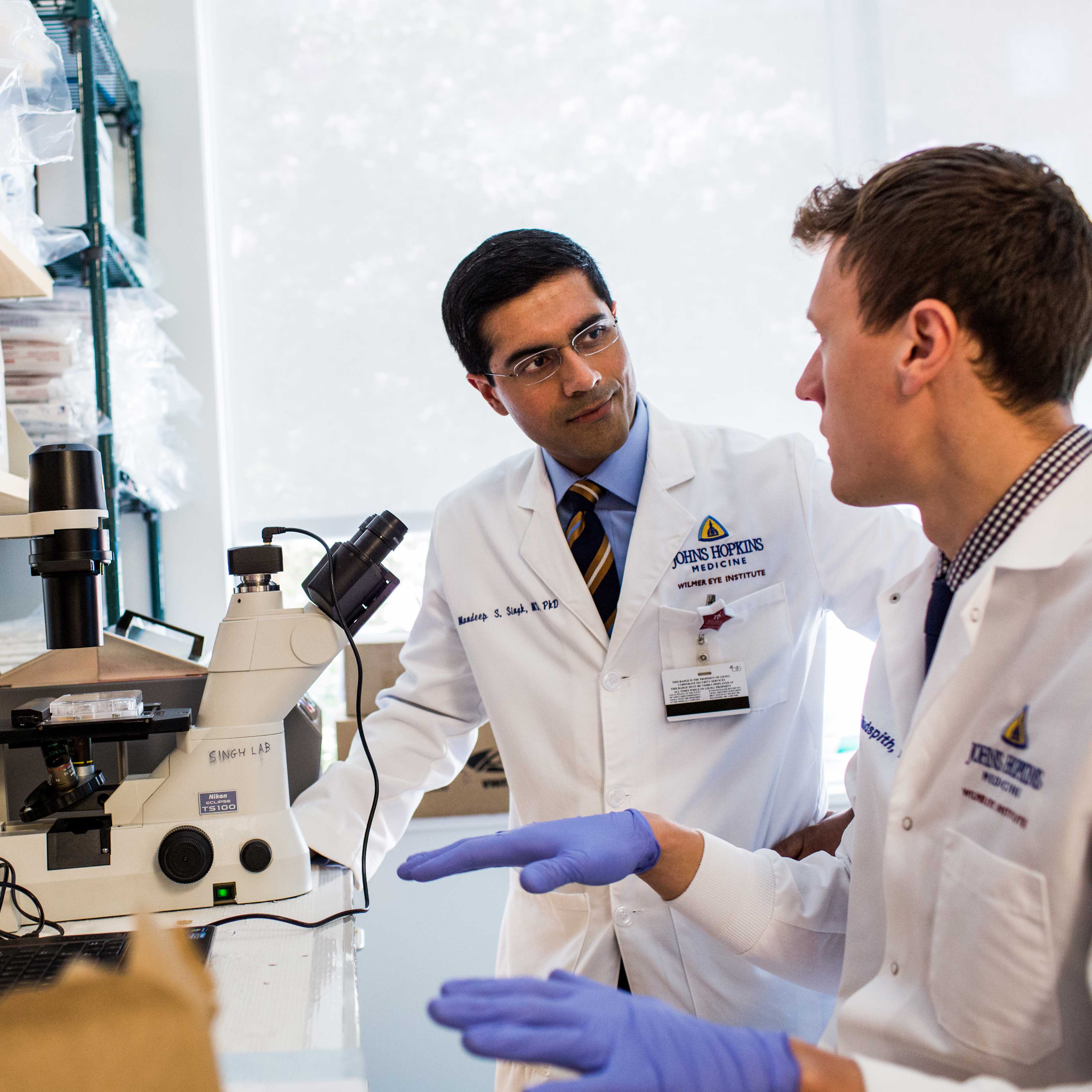 Dr. Mandeep Singh and Karl Hudspith discuss research in the Wilmer Eye Institute lab.