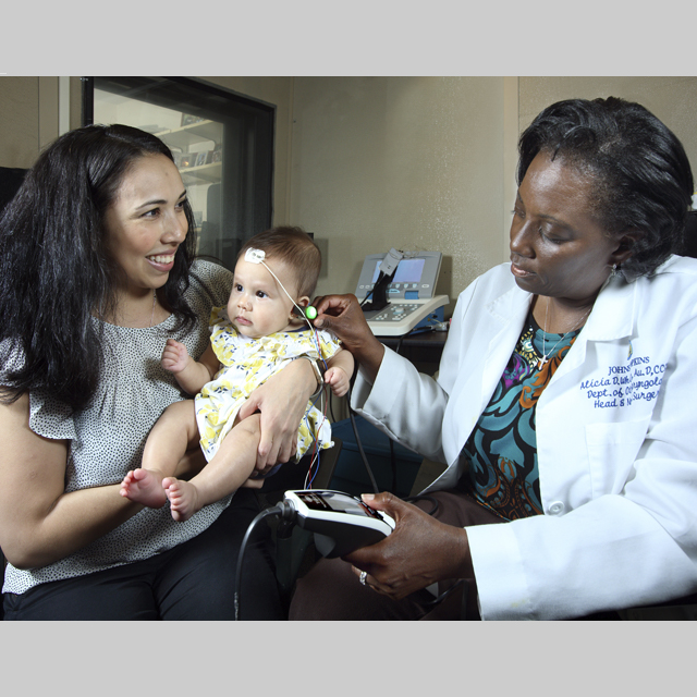 Audiologist Alicia White and young patient with mom