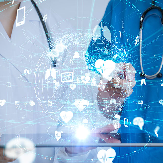 A photo illustration shows two doctors, one in blue scrubs and one in a white lab coat, holding a laptop over which a globe and medical symbols are illustrated.