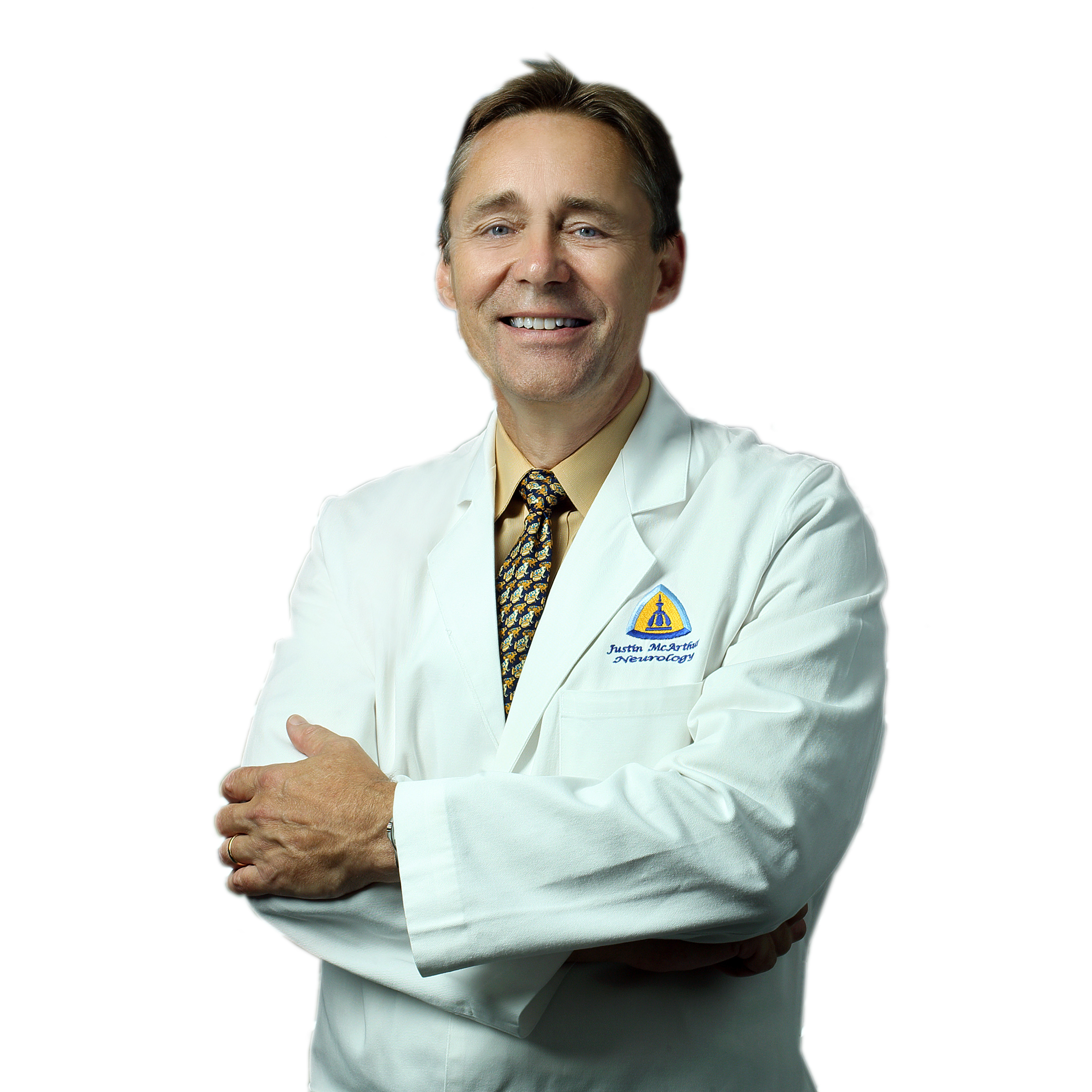 Dr. Justin McArthur stands by windows at The Johns Hopkins Hospital in a traditional white lab coat.