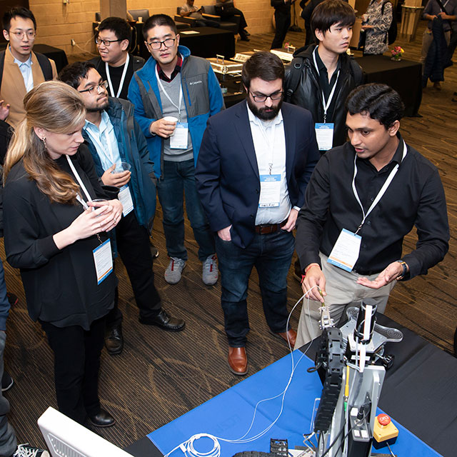 Nirav Patel, a postdoctoral fellow in a lab at the Whiting School of Engineering, demonstrates a robotic assistant for retinal surgery at Johns Hopkins University’s research symposium on engineering in health care. 
