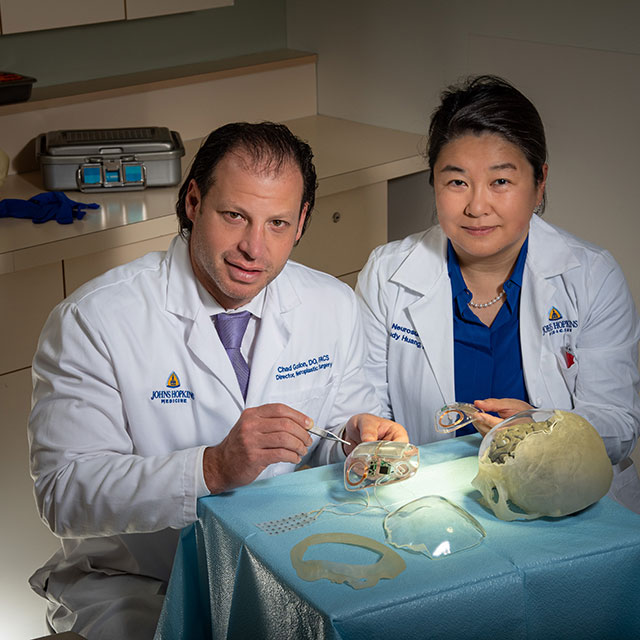 Two Johns Hopkins doctors work on rebuilding a skull. (File photo, March 11, 2020)