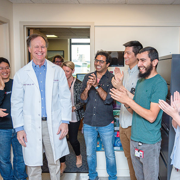 Bill Kaelin is greeted with cheers from his lab team.