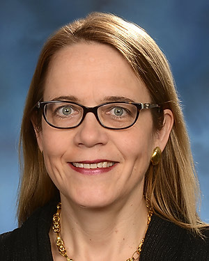 Portrait of Ulrike Buchwald wearing glasses and black professional attire.