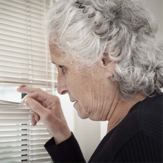 Elderly woman looks out the window