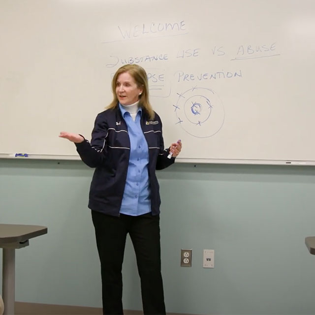 Beth Kane-Davidson in front of a classroom. 