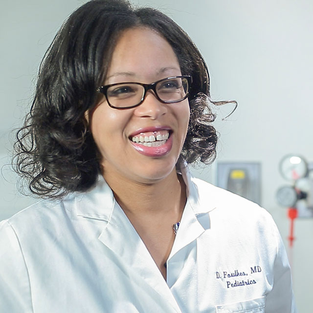 image of Dr. Dominque Foulkes, laughing, in a white coat. 