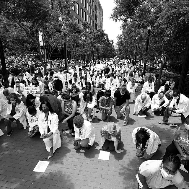 A photo of Doctors and Nurses kneeling in response to the Black Lives Matter movement.