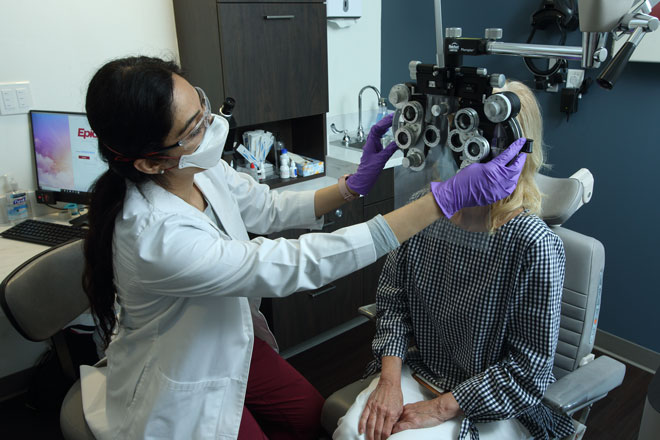 Dr. Mona Kaleem examines a patient's eyes in the Wilmer glaucoma clinic.