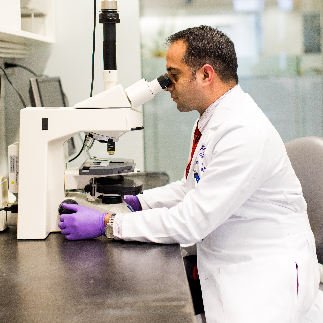 Dr. Amin Herati looking into microscope