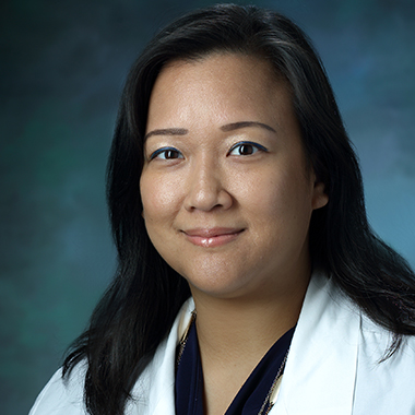 Karen Wang in a formal portrait wearing a white lab coat and navy blue blouse.