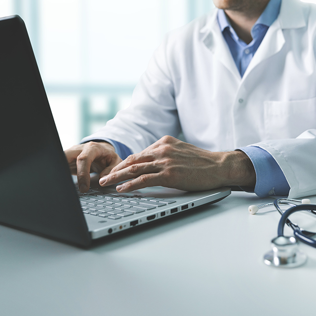 Photo of doctor typing on computer.