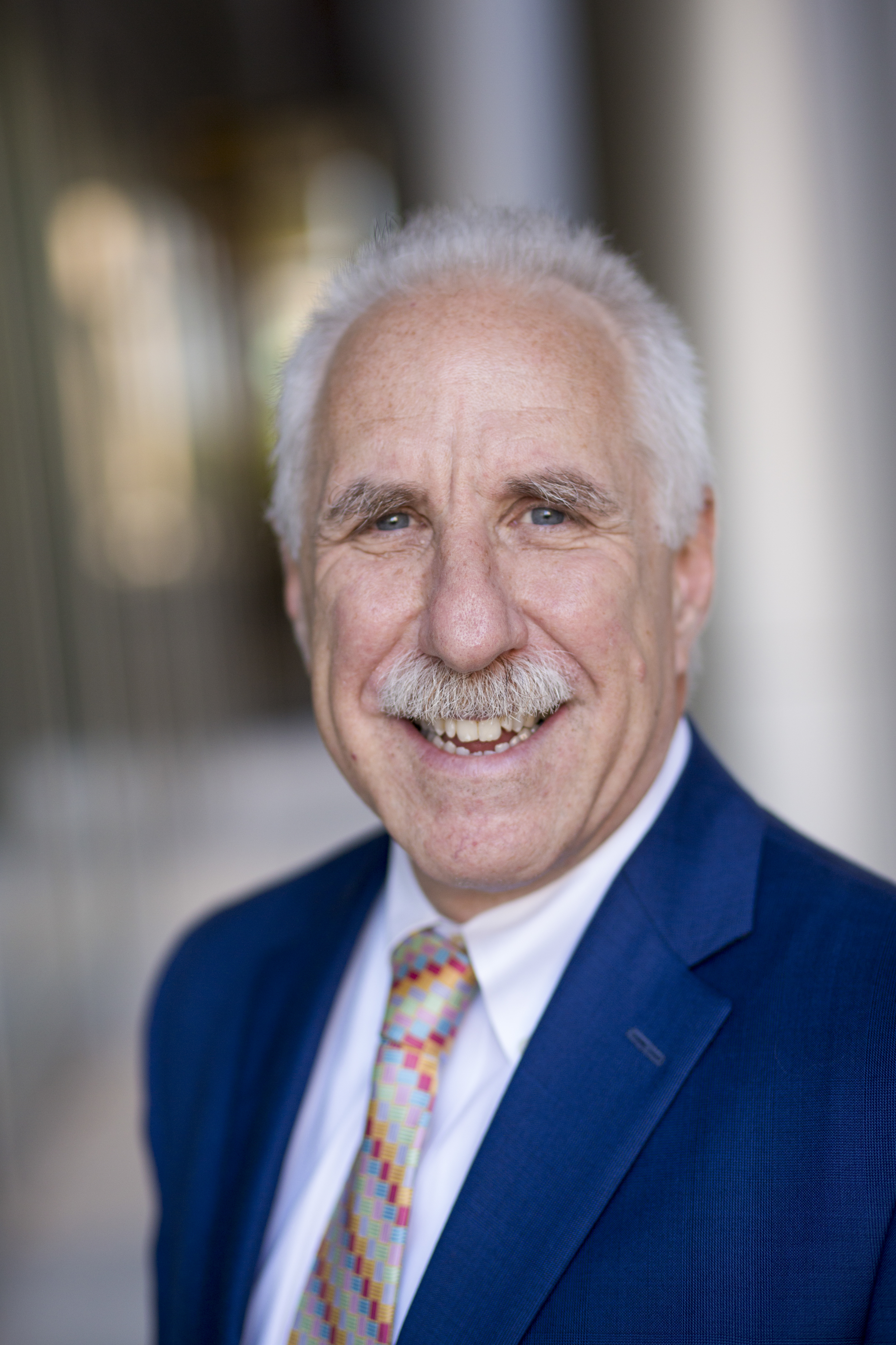 head shot of Dean Rothman in a blue jacket and plaid tie