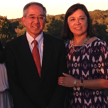 John Otsuki and Loretta Yenson at sunset, he's wearing a suit and she is in a dress. 