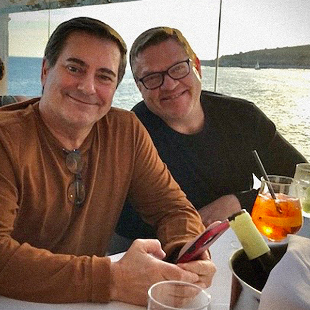 Photograph of Thomas Koenig and Ciro Martins with a view of a bay behind them