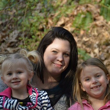 Whitney Sussex with daughters Addy and Lilly, in an outdoor, sun-dappled pose. 