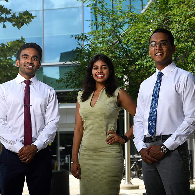 Three male students and one female student who are board members of the Johns Hopkins chapter of the South Asian Medical Student Association stand together outside.