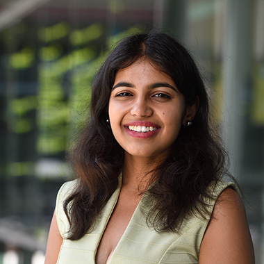 An outdoor portrait of medical Pranjal Agrawal, who is wearing a light green dress. 