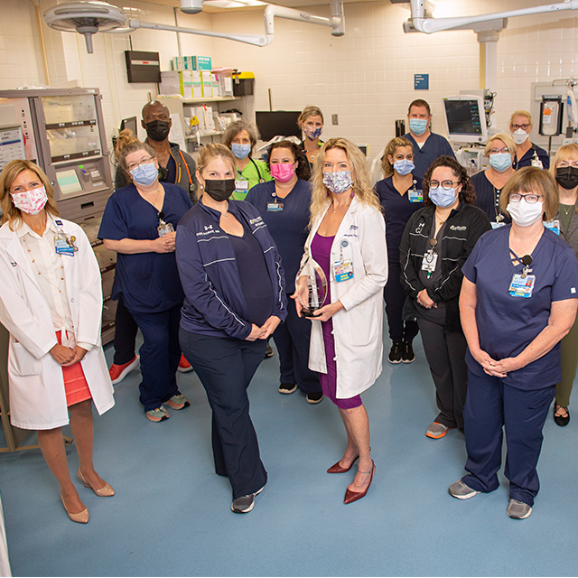 Seventeen Suburban Hospital ED nurses, all in masks and most in scrubs, gather to celebrate their second consecutive Lantern Award.