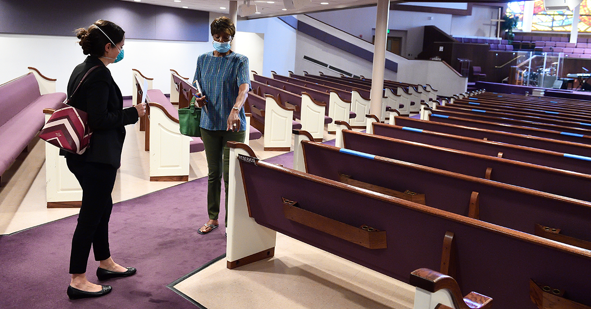 Dr. Katie O'Conor discusses recommended distancing with a member of Israel Baptist Church.