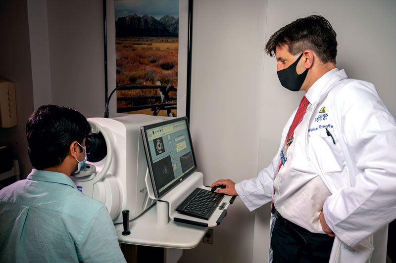 Dr. Amir Kashani reviewing optical coherence tomography (OCT)and angiography (OCTA) images