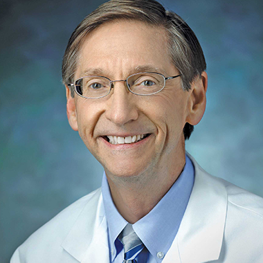Portrait of James Segars in a white coat.
