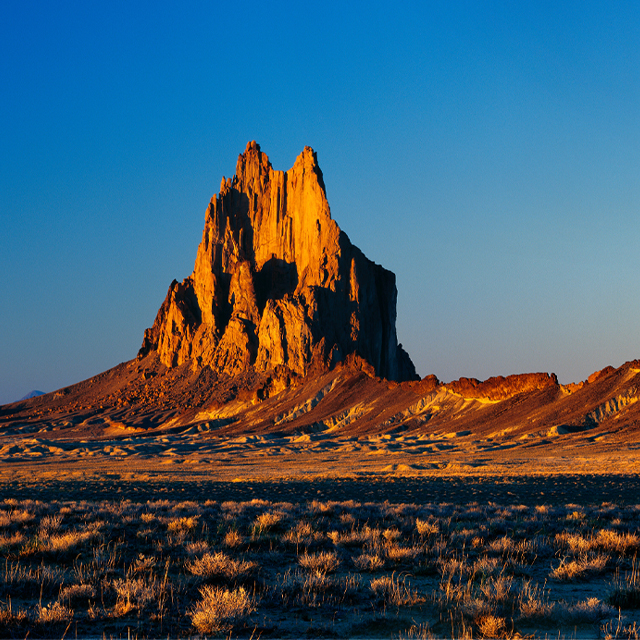 A rocky ridge juts out from a desert landscape.