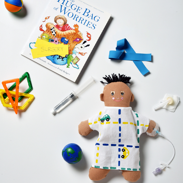 photograph if children's book, soft doll with colorful scrubs and small medical objects