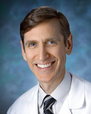 A photo shows John Carey.