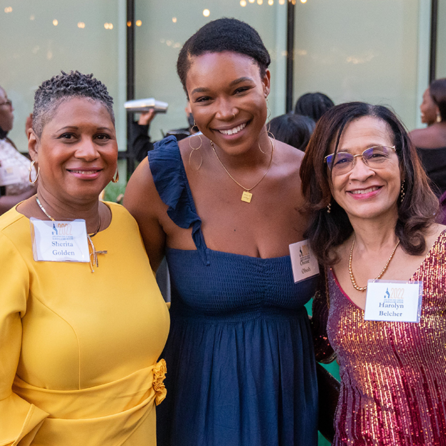 Three women stand together at the reunion weekend.