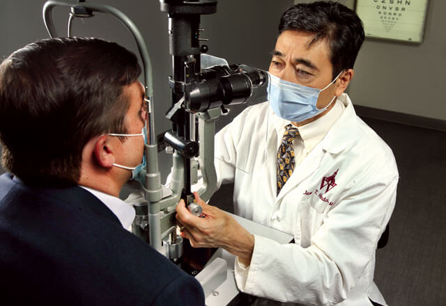 James Handa performs an eye exam on Jeff Stevenson