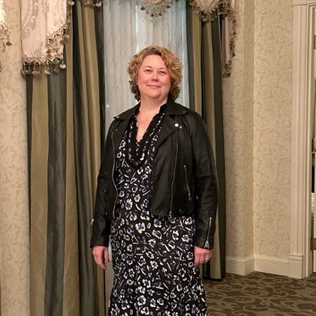Ann O’Brien wearing a black and white dress and black leather jacket