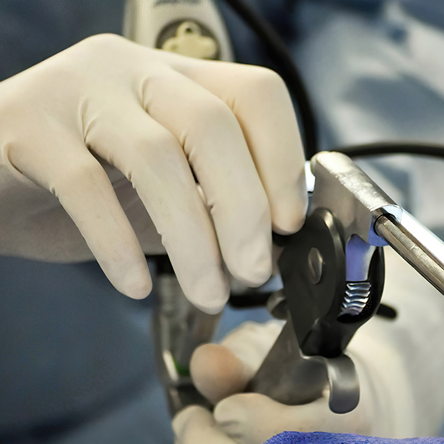 Close-up of larnyngologist's gloved hands holding medical device