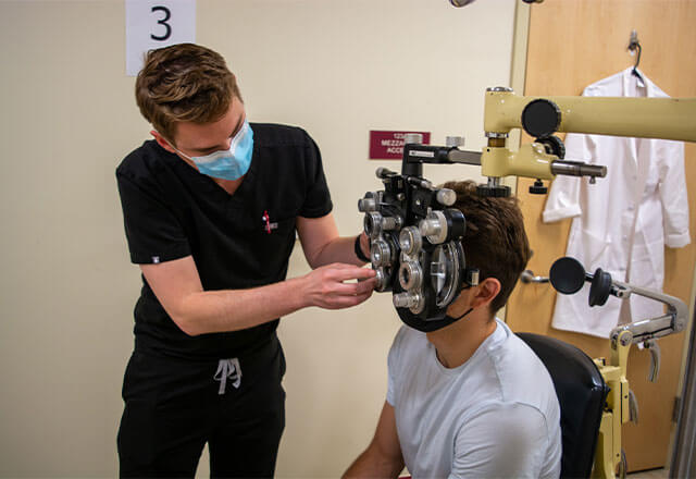 Bryce Patrick St Clair, O.D conducts an eye exam for a patient at CASA.