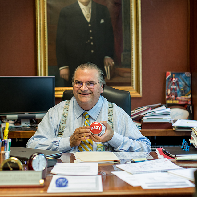 Alan Partin sits at his desk with an easy button in hand.
