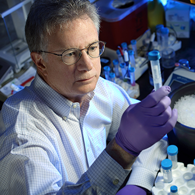 Timothy Moran looking at a test tube.